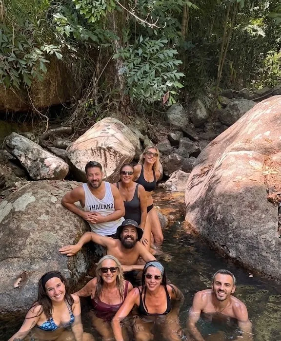 Grupo de viajeros bañándose en un río de la selva en Tailandia